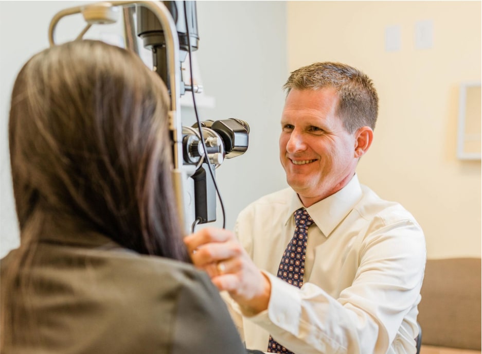 An eye doctor performing an eye assessment to a patient