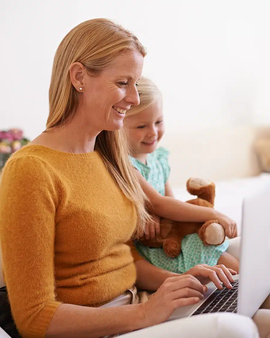Grandmother and grandson looking through a laptop together, representing everyday activities affected by age-related vision improvements thanks to RLE, Refractive Lens Exchange surgery in Las Vegas.